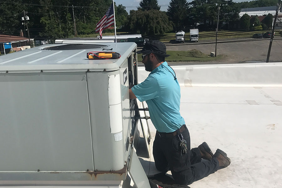 Technician repairing a commercial HVAC unit in Manasquan NJ