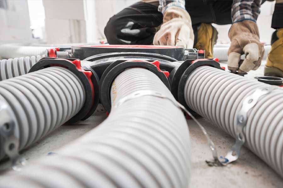 Technician connecting heat recovery ventilator ducts in a Manasquan, NJ home