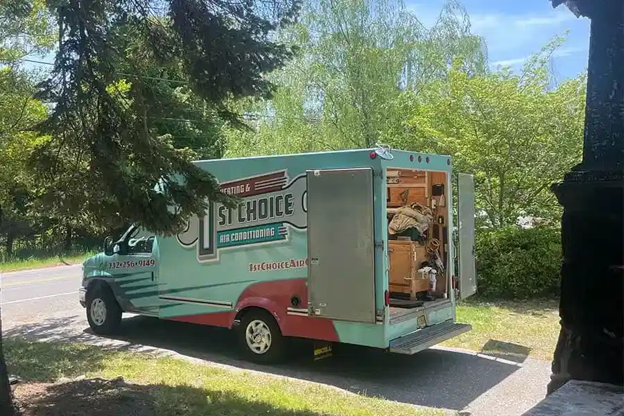 1st Choice Air Comfort HVAC service truck parked in a driveway with rear doors open and tools inside.